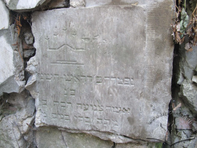 Ul. Generała Czuprynki, 96. Fragment macewy z dawnego cmentarza żydowskiego we Lwowie. Macewy byli stosowane do budownictwa ściany podporowej w północnej części działki